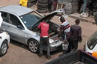 A group of people repairing a car