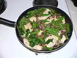 8. Return mushrooms and peas to pan; add wine/water/rosemary/parsely mixture/