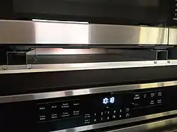 The exhaust duct (a tray-like element) and the two bottom mounting rails are included in the trim kit