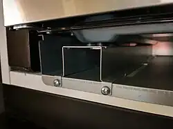 The exhaust duct and one of the bottom mounting rails (detail); the appliance stands on the rails which in turn rest on the exhaust duct
