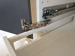 Custom installation is an option only for interior drawers; here, it helped to avoid the collision with a door hinge.