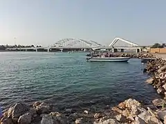 The Maqta' Bridge (Arabic: جِسْر ٱلْمَقْطَع, romanized:&nbsp;Jisr Al-Maqṭaʿ; front) and Sheikh Zayed Bridge (Arabic: جِسْر ٱلشَّيْخ زَايِد, romanized:&nbsp;Jisr Ash-Shaykh Zāyid; back) at Al-Maqṭaʿ (Arabic: ٱلْمَقْطَع), which connects the island of Abu Dhabi to the mainland