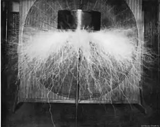 Prototype "magnifying transmitter" in Tesla's New York lab around 1898 producing 2.5 million volts. The round "spiderweb" secondary coil is visible in background