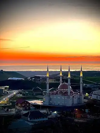 центральная мечеть села на фоне заката и Каспия