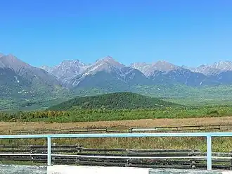 На переднем плане выступает сопка Вулкана Черского, на заднем плане расположены горные хребты Саян (13 сентября 2021 года)