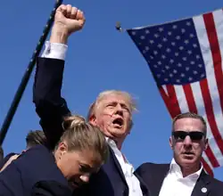 Секретная служба уводит Дональда Трампа от трибуны сразу после покушения. Фотография Эвана Вуччи➤