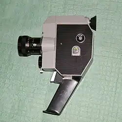 Крышка отсека киноплёнки с замком, вверху — гнездо для рукоятки обратной перемотки