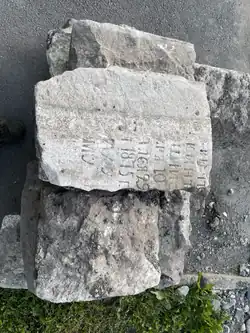Могильная плита 1875 года, использовавшаяся в качестве бордюра. Обнаружена в мае 2022 года во время замены бордюров.