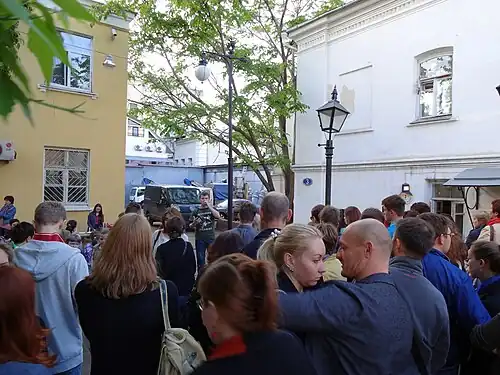 Выступление молодого поэта во дворе музея перед посетителями, ожидающими экскурсию