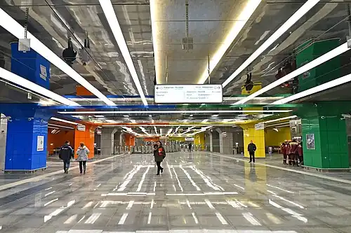 Распределительный холл перед турникетами, по бокам эскалаторы к платформам