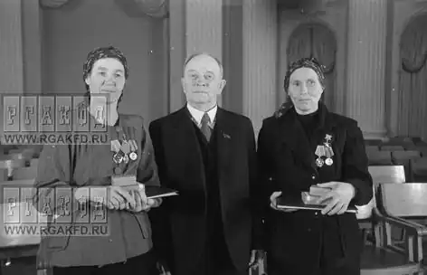 О. В. Куусинен и Герои Социалистического Труда бригадиры полеводческих бригад подсобного хозйства им. Куйбышева при Кузнецком металлургическом комбинате Н. П. Бедарева (слева) и К. Н. Пономарева (справа) после вручения наград