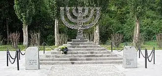 Искажённый вариант памятника. После вандализма основание памятника было облицовано камнем другого цвета, с которым автор проекта не был согласен. (Пьедестал по проекту должен был быть тёмным, чтобы, когда подходишь к памятнику, он как бы поднимался из земли.)