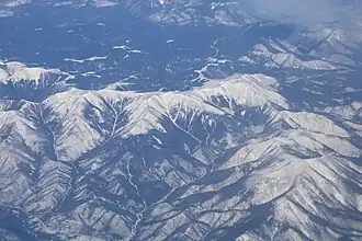 На хребте в средней части снимка, слева направо: Острая (1758), высота 1751, высота 1703. Вид с высоты 11300 м, рейс Владивосток - Южно-Сахалинск.