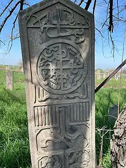 Стела в г. Курчалой вверху изображён солярный символ.