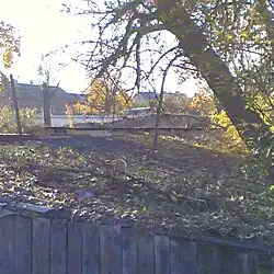 Руины стены Среднего города. Вид с востока со стороны ул. Красных партизан (ранее ул. Казанская), на переднем плане — хоз. дерев. постройка.