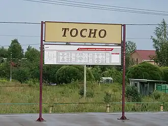 Прежний указатель с названием станции и расписанием электропоездов.