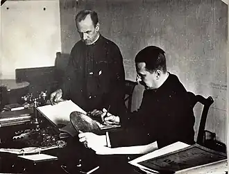 В кабинете учёного секретаря Эрмитажа. М. Д. Философов (сидит) и делопроизводитель Б. И. Игнатьев. На заднем плане — диван Пушкина.Конец 1920-х годов