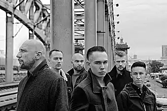 Концертный состав группы в 2015–2019 годах. Слева направо: Андрей «Бледный» Позднухов (МС), Максим Соколов (гитара), Тарас Андреев (ударные), Антон «Ант» Завьялов (вокал, МС), Богдан Солодовник (бас-гитара), Рустам Мунасипов (гитара)