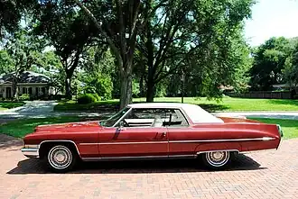 1972 Cadillac Coupe Deville, округлые боковины, длинный молдинг, рассекающий задний светоотражатель и хромированная окантовка арок колёс и порогов