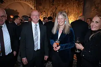 Стоит третья слева (14 февраля 2025)