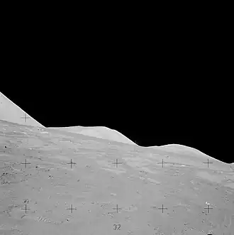 Молоток упал, взбив фонтан лунной пыли (чуть ниже ложбины между двумя холмами)