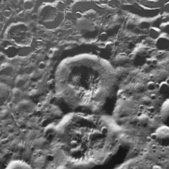 Кратер Аладдин — в центре. Ниже видно кратер Али-Баба, а выше и правее — сильно разрушенный кратер Зайнаб. Мозаика снимков «Кассини».