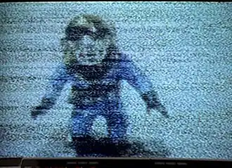 Декоративная фигурка водолаза в аквариуме, полученная из кадра со статическими помехами.