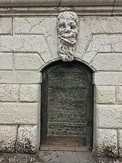 Маскарон украшает входную дверь колокольни