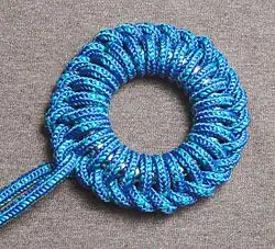 Оплетение кольца петлями с нижним положением ходового конца[англ.]:235, Двойное оплетение кольца:198, Ringbolt hitching, Continuous ring hitching, Single ringbolt hitching, Kackling, Keckling.Декоративная свайка кладётся на прихватки сундуков или на кольца гамаков.