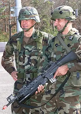 Генерал-лейтенант (LGEN) Джозеф Инге, командующий 1-й армией, и специалист (SPC) Антонио Сото, 1-й батальон 69-го пехотного полка Национальной гвардии армии Нью-Йорка, позируют для фотографии во время визита LGEN Инге в Форт-Дикс, штат Нью-Джерси. SPC Сото вооружен 5,56-мм штурмовой винтовкой M16A2 с прикрепленным 40-мм гранатометом M203 и оснащен системой множественного интегрированного лазерного поражения (MILES).