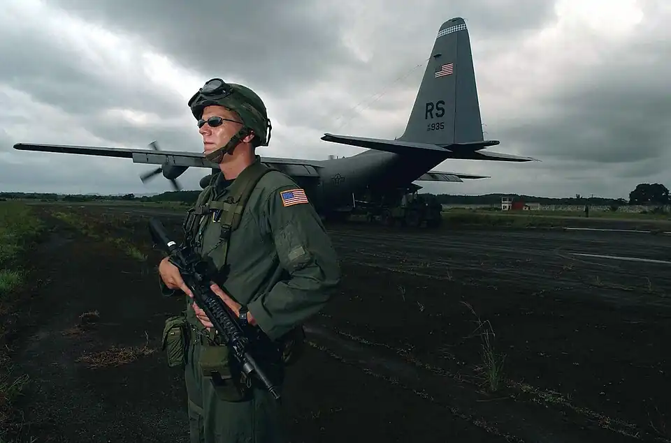 Штаб-сержант (SSGT) ВВС США (USAF) Бен Берк, 786-я эскадрилья сил безопасности (SFS) «Вороны», 398-я воздушная экспедиционная группа (AEG), вооружен карабином M4 калибра 5,56 мм, обеспечивая безопасность самолета ВВС США C-130 Hercules из 37-й воздушной эскадрильи на летном поле в международном аэропорту Робертс в Монровии, Либерия, во время учений Объединенной оперативной группы (JTF) в Либерии.