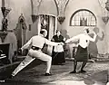 На съёмках фильма «Огни рампы» (1921): режиссёр Джон Робертсон[англ.] даёт Фергюсон урок фехтования