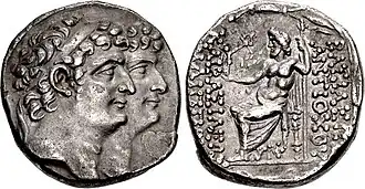 Coin minted by Antiochus XI and Philip I. The obverse depict them together with Antiochus XI appearing ahead of Philip. The reverse contain the kings' names to the right and their epithets to the left. In the middle of the reverse, Zeus is depicted sitting on a throne holding a sceptre and holding a Nike in his hand which is stretched toward the inscription of the epithets.