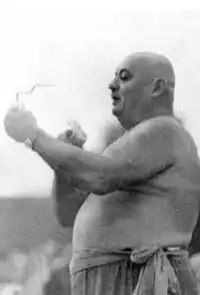 Силач Иван Фирцак-Кротон демонстрирует свой номер — сворачивает сердце из гвоздя