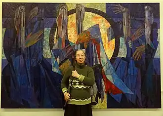 На фоне картины своего мужа