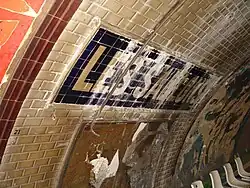 Фрагмент путевой стены с названием станции в процессе реновации