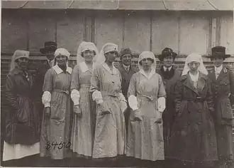 Группа работников ARC в столовой Красного Креста. Слева направо: мисс Анна Л. Рочестер, мисс Глэдис Кромвель, мисс Элизабет Стрэнг, мисс Хелен Дж. Дэй, мисс К. Уэллер, миссис Мэри Палмер Гарднер, мисс Уинифред Брайс, мисс Анна. А. Райан, мисс Джулия Уэллс и мисс Дороти Кромвель. Больницы ARC № 6 и 7, Суйи, Маас, Франция, 13 октября 1918 года