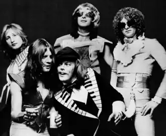 Mott the Hoople в 1974 году. (Слева направо: Дейл Гриффин[англ.], Лютер Грозвенор[англ.],  Морган Фишер[англ.] (фронт), Пит Оверенд Уоттс[англ.], Иэн Хантер)