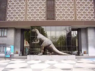 Статуя игуанодона перед входом в новое здание института