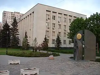 На фоне здания Святошинской районной администрации