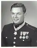 A black and white image showing the head and torso if Pittman wearing his Marine Corps dress uniform with medals. His Medal of Honor is visible around his neck.