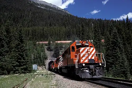Поезд выходит из тоннеля на перевале «Большой холм» (англ. Big Hill) Канадской тихоокеанской железной дороге в Британской Колумбии[англ.] (англ. Canadian Pacific Railway in BC)