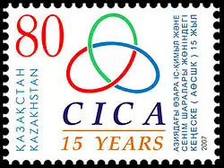 Правильно раскрашенный в три цвета левый трилистник на почтовой марке Казахстана, посвящённой 15-илетию СВМДА