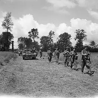 Бронетранспортеры Universal Carrier и пехота 15-й (шотландской) пехотной дивизии продвигаются вперед во время операции «Блюкот», 30 июля 1944 года