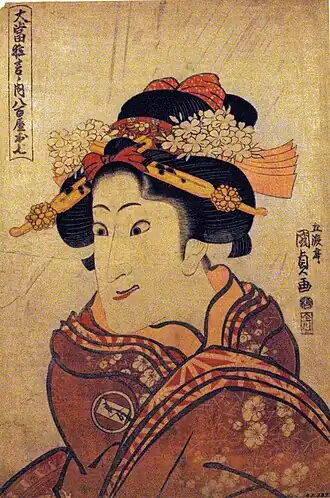 Актёр Иваи Хансиро V[англ.] в роли О-Сити. Гравюра Утагавы Кунисады (между 1812 и 1816 годами). Актёр одет в кимоно с гербом «конверт в круге» на плече, на нижних кимоно заметен узор аса но ха