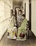 Three prostitues posing on an engawa in Yokohama, ок. 1885. Фотография, раскрашенная вручную.