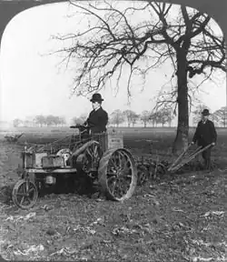 A black-and-white photo of a man on an (1902 model) «Ivel» tractor