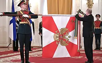 Президент Владимир Путин прикрепляет ленту ордена Суворова на боевое знамя Краснознамённого Южного военного округа