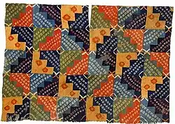 Одежда уари, Перу, 750—950 гг. Эта туника была изготовлена из 120 отдельных кусков ткани, каждый из которых был окрашен индивидуально. На керамике того же периода в подобных одеждах изображены мужчины с высоким социальным статусом. Коллекция Текстильного музея