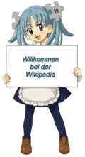 Википе-тан с табличкой (на немецком языке) «Добро пожаловать в Википедию»